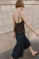 Top de tirantes finos con escote drapeado y diseño fluido. Presenta un estampado de lunares celestes sobre fondo marrón.