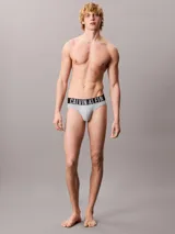Pack de tres slips Calvin Klein de talle medio con cinturilla elástica distintiva de la marca. Incluye uno de color gris, uno negro y uno celeste.