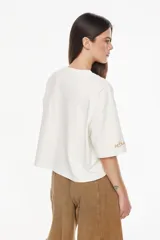 Remera de algodón con elastano, de moldería boxy y calce relajado, color blanco. Presenta un bordado exclusivo de un atardecer en tonos azules en el pecho.