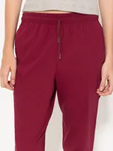 Pantalón babucha color borgoña, confeccionado en algodón liviano. Presenta cintura elastizada con cordón ajustable, bolsillos laterales y botamangas levemente entalladas.