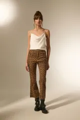 Pantalon jean de tiro alto con corte flare y ruedo desflecado, estampado con diseño animal print de leopardo en tonos marrones.