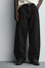 Jeans de denim de algodón color negro, con corte balloon fit relajado desde la cadera y ligeramente estrechado en el bajo. Tiro medio, cinco bolsillos y cierre frontal con cremallera y botón.