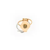 Anillo dorado con dije en forma de rombo y piedra verde en el centro.