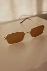 Lentes de sol rectangulares con armazón metálico dorado y lentes marrones con protección UV400.