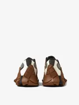 Zapatillas multicolor con malla Sorona, empeines de HyphaLite y MIRUM, cordones de TENCEL Lyocell, plantillas OrthoLite Recycled, entresuelas de EVA de caña de azúcar y suelas de goma. Presentan una combinación de tonos marrones, grises, negros y blancos, con un diseño robusto y texturizado.