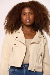 Chaqueta tipo biker de gamuza en color beige, con cierre frontal cruzado, bolsillos laterales con cierre y solapas con botones metálicos decorativos.