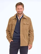 Chaqueta de gamuza color tostado, con cuello camisero, cierre frontal de botones y dos bolsillos frontales con solapa y botón.