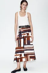Falda midi de tiro alto en tejido de popelín con diseño evasé. Presenta un estampado geométrico en tonos tierra, crema y negro, e incluye un cinturón a juego con hebilla metálica dorada. Cuenta con cierre lateral mediante cremallera oculta.