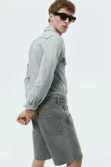 Bermuda de cinco bolsillos en denim de algodón grueso. Modelo de cintura estándar con cierre y botón, y piernas de corte relajado.