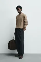Sweater de punto color beige, de corte relajado, con cuello redondo y diseño texturizado en estructura waffle.