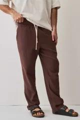 Pantalón de tiro medio con cintura elástica y cordón ajustable, textura tejida, corte recto y silueta amplia.