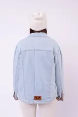 Campera de jean color celeste claro, con cuello camisero, botones frontales y bolsillos con solapa en el pecho.