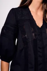 Blusa negra de algodón peinado con calce oversize, escote en V, mangas tres cuartos abullonadas y detalles de encaje y bordados en el frente y mangas.