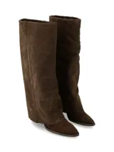 Bota de caña alta confeccionada en cuero gamuza color chocolate, con diseño de polaina incorporada y taco bajo.