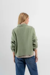 Chaqueta corta tipo blazer color marrón, confeccionada en tela de lana afieltrada. Tiene cuello camisero, silueta cuadrada, cierre frontal con botones y bolsillos delanteros.