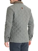 Chaqueta de lana con diseño acolchado de rombos, cierre frontal con broches metálicos y cuello de cotelé en contraste. Cuenta con dos bolsillos frontales tipo parche y un calce regular.