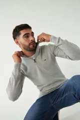 Sweater azul marino de punto con cuello alto y medio cierre con cremallera. Tiene mangas largas y logo bordado en el pecho. Corte regular.