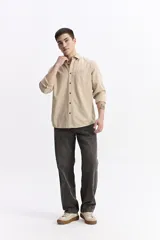 Camisa de manga larga color azul marino con textura, cuenta con cuello clásico, cierre frontal con botones y un bolsillo en el pecho.