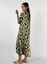 Vestido largo con estampado animal print en tonos marrones y blancos, con cuello en V y mangas cortas con ribete blanco.