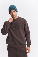 Buzo de algodón color marrón chocolate, con cuello redondo, mangas largas y estampa frontal con el nombre de la marca repetido en tono sobre tono.