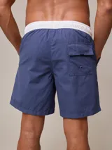 Short de baño azul con cintura elástica blanca y cordón ajustable.