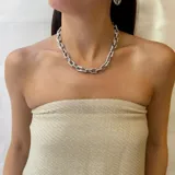 Collar corto de cadena de eslabones gruesos, con diseño bicolor que combina eslabones dorados con eslabones plateados incrustados con zirconias brillantes.