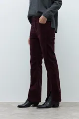 Pantalón de pana de corte recto y tiro medio, color ciruela, con detalle de tajo en el ruedo.