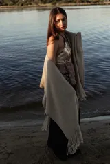 Ruana de lana merino en color tostado, con diseño de punto texturizado y terminación de flecos en el ruedo.