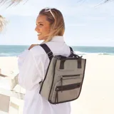 Mochila y cartera híbrida confeccionada en nylon de color beige con detalles y correas en negro. Posee dos asas superiores para llevar al hombro y correas traseras ajustables para usar como mochila. Presenta dos bolsillos frontales con cierre de cremallera y tiradores largos.