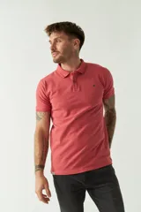 Remera polo blanca de manga corta, con cuello clásico, cierre de tres botones y logo estampado en el pecho.