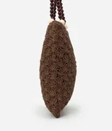 Bolso de mano tipo tote, tejido en punto de ganchillo con textura de conchas, color marrón oscuro. Las asas son de cuero o material sintético oscuro, adornadas con cuentas redondas de madera en tonos marrón oscuro, borgoña y crema.