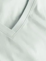 Remera Calvin Klein de manga corta y cuello en V, color verde menta pálido. Presenta una etiqueta con el logo de la marca en la parte posterior del cuello.