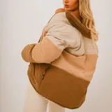 Campera puffer color block en tonos beige, tostado y marrón, con diseño acolchado, cuello alto y cierre frontal con cremallera.