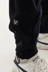 Pantalón de jogging azul marino de algodón grueso con interior cálido, corte amplio, tiro medio, cintura elástica con cordón, cierres en los tobillos y logo "vernal" bordado en la pierna izquierda.