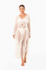 Vestido playero largo de encaje blanco con volados, mangas largas, abertura frontal con lazos para cerrar y aberturas laterales.
