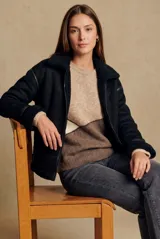 Campera tipo gamulán de corte oversize, color negro, con interior y cuello de corderito sintético. Presenta cierre frontal, detalles de costuras y puños con terminación en corderito.