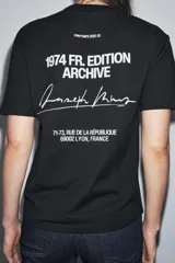 Camiseta negra de manga corta y cuello redondo, con estampado pequeño en blanco en el pecho que dice "1974 FR. ARCHIVE".