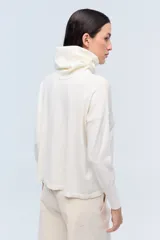 Polera color crema de tejido de punto jersey, con cuello amplio y mangas largas.
