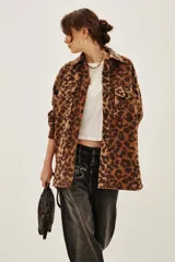 Tapado tipo sobrecamisa con estampado animal print, de corte recto y largo a la cadera. Presenta cuello camisero, cierre frontal con botones y dos bolsillos frontales con solapa.