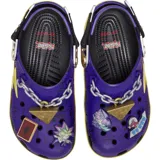 Zuecos Crocs Classic edición especial Yu-Gi-Oh!, de color morado con detalles gráficos de rayos en amarillo y fucsia, correa trasera ajustable y dijes Jibbitz temáticos que incluyen el Rompecabezas del Milenio y una carta de duelo.