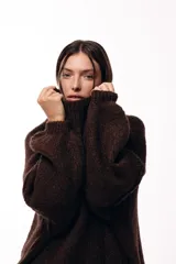 Sweater de punto grueso con cuello alto, diseño de hombros caídos y mangas amplias con puños acanalados.