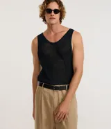 Musculosa de hombre color azul marino oscuro, con textura de tejido de ganchillo abierto y escote en V pronunciado.