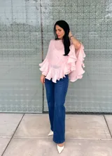 Blusa color rosa pálido de gasa con volados en las mangas y en el ruedo.