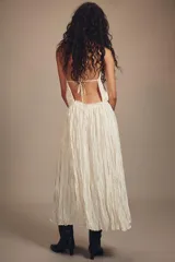 Vestido largo de cuello halter con diseño plisado y textura arrugada. Presenta espalda descubierta con cierre de lazo y cintura elástica.