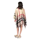 Poncho abierto de tejido de punto con diseño de cuadros escoceses en tonos beige, negro, blanco y detalles en rojo. Presenta terminaciones con flecos en el ruedo.