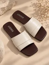 Sandalias planas de diseño minimalista con plantilla marrón oscuro y faja ancha superior de ecocuero color marfil.