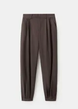 Pantalón balloon de tiro medio color marrón oscuro, con diseño de pinzas, trabillas y bolsillos laterales. Cuenta con cierre de gancho y cremallera.
