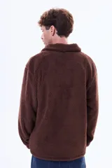 Campera de sherpa color marrón con cierre frontal completo, cuello alto y bolsillo frontal con cierre en contraste de material.