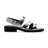 Sandalias plateadas con tiras horizontales y verticales, con detalles de ojales metálicos. Tiene una tira trasera con hebilla y un pequeño taco cuadrado negro.