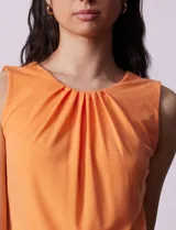 Musculosa negra de poliéster y elastano, con cuello redondo con frunces delanteros y abertura con botón en la espalda.